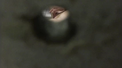 Озабоченный чел подглядывает за телкой через дырку в стене